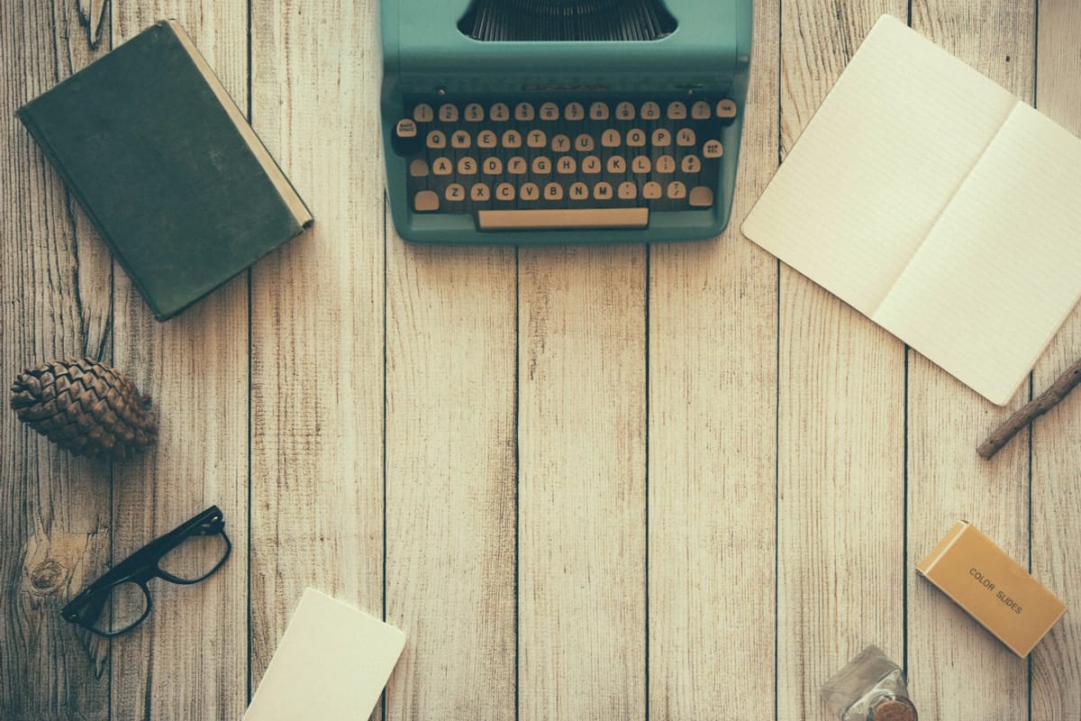 An open notebook and pen on a wooden desk